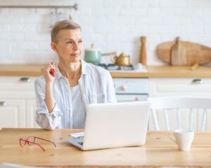 woman considering an IRA with a laptop in the kitchen